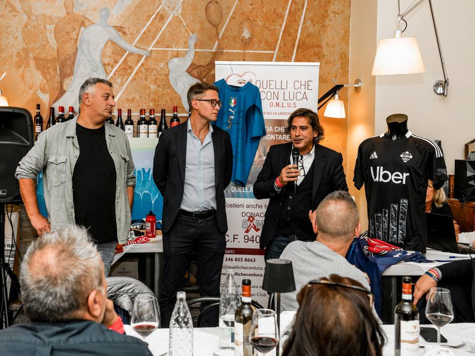 A black Como 1907 third shirt is displayed on a mannequin during a club event.