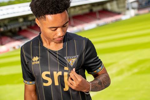 A model presents the Dunfermline Athletic FC 2024/25 away shirt at East End Park.
