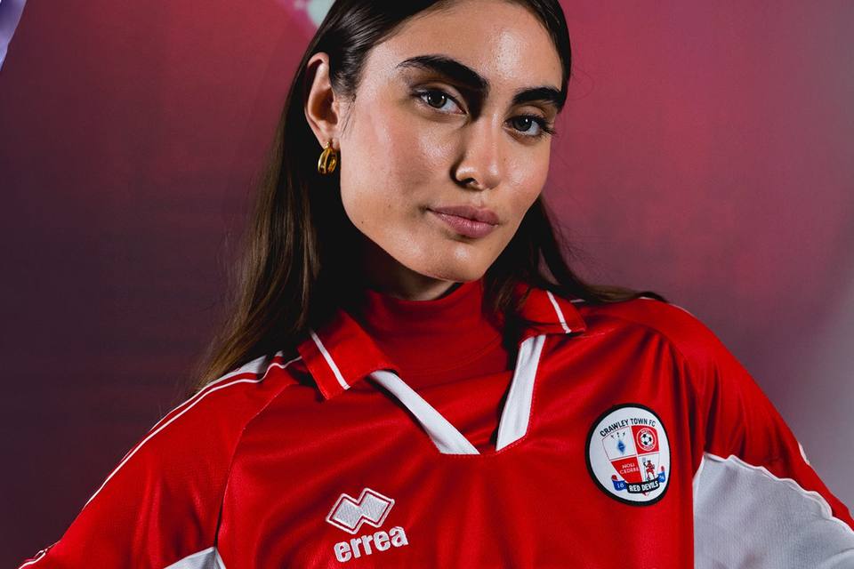 A model wearing the Crawley Town FC 2025/26 home shirt by Erreà.