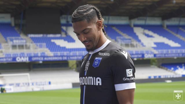 A player wearing the AJ Auxerre 2023/24 away football shirt inside the stadium.