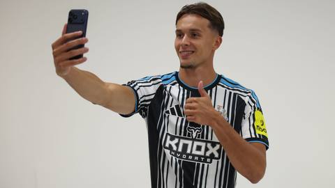 A player smiles while taking a selfie in Newcastle United's 2026/27 away shirt.