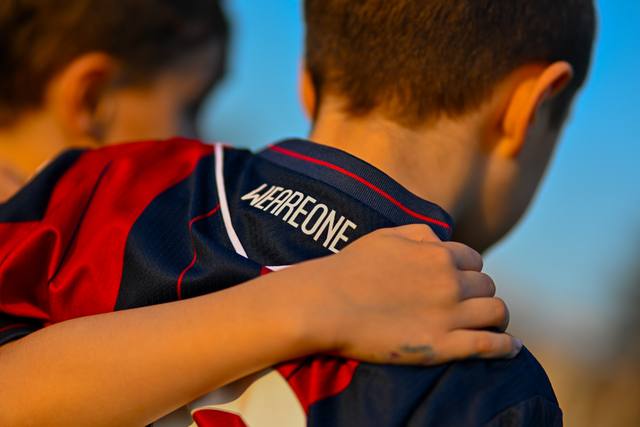 A close-up shot of the back collar of a Bologna FC 1909 home shirt, showing the club's motto 'WEAREONE' printed on the collar.