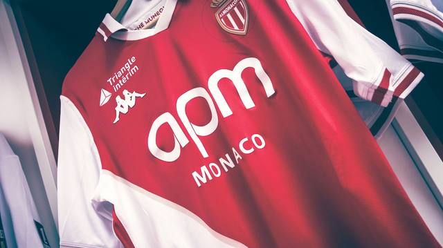 A close-up view of the AS Monaco 2024/25 home shirt on a hanger, featuring the iconic red and white diagonal design.
