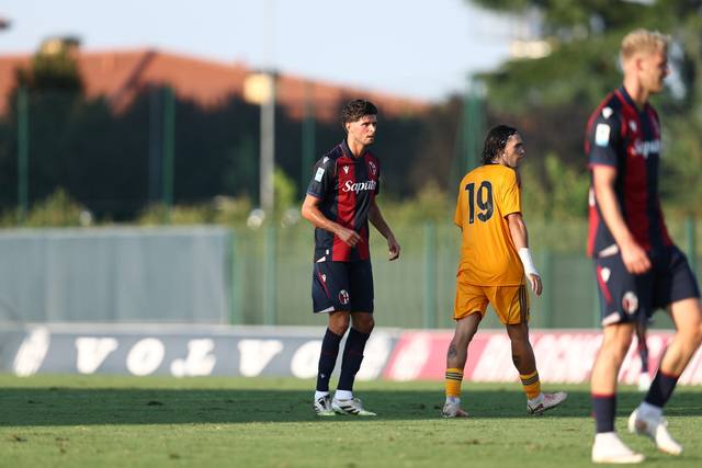 Bologna FC 1909 players wearing their red and blue striped home kit during a match.