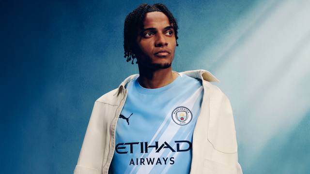 Manchester City player Manuel Akanji wearing the 2025/26 home shirt featuring a diagonal sash design.