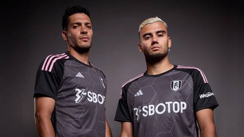 Raúl Jiménez and Andreas Pereira pose in the Fulham FC 2023/24 third kit, featuring a black geometric pattern and pink details.
