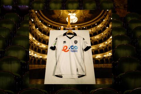 The Cesena FC 2025/26 home shirt by Erreà presented on an easel in a classic theatre setting.