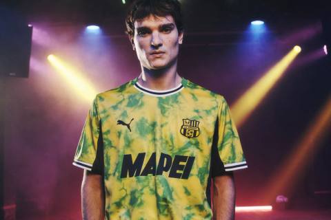 A model wears the U.S. Sassuolo 2025/26 third kit by Puma, featuring a yellow and green tie-dye design.