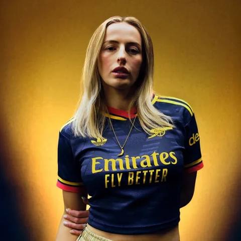 A model wearing the Arsenal away shirt featuring the yellow cannon crest and Adidas Trefoil logo