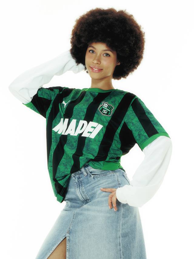 A model wearing the Puma U.S. Sassuolo Calcio home shirt with green and black vertical stripes.