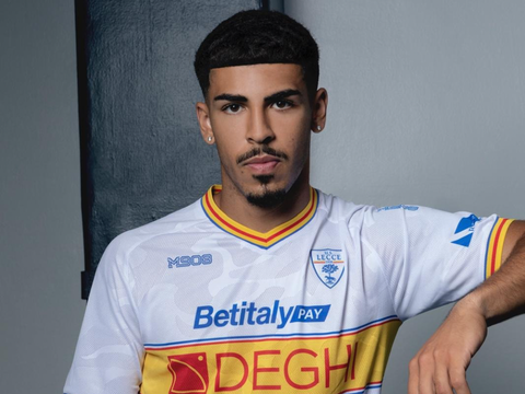 A player wearing the US Lecce away shirt featuring a white base with yellow and red accents.