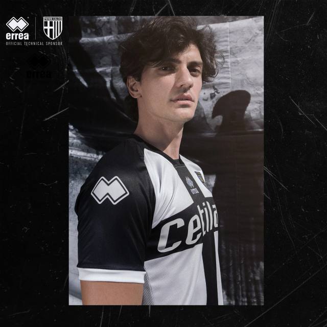 A model poses wearing the Parma Calcio 2020/21 home football shirt by Erreà.