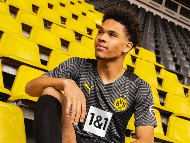 Borussia Dortmund 2021/22 away shirt worn by a model in the stadium stands